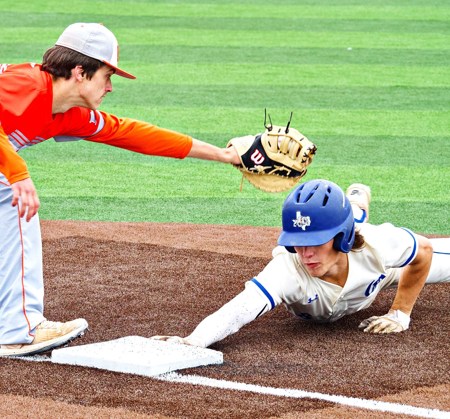 Solid spring showers forced Mineola and Quitman to relocate their matchup to the artificial turf of Grand Saline's baseball facility April 16. Here, Quitman's Mason Reynolds slides under the tag of Mineola first baseman James Clower. [see more sports from throughout the year]